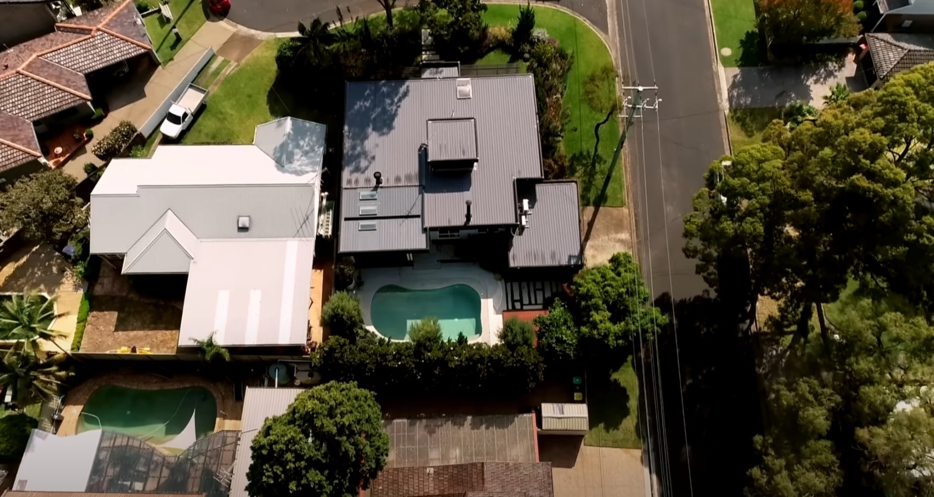 Aerial view of residential property with swimming pool and professional landscape design